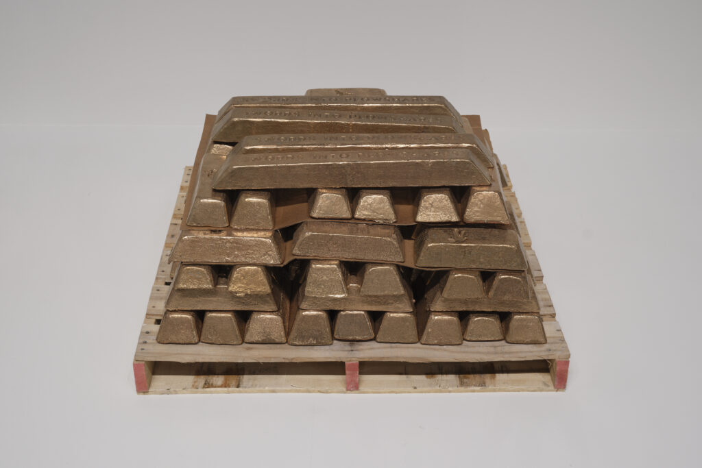 A stack of bronze ingots on top of a wooden pallet