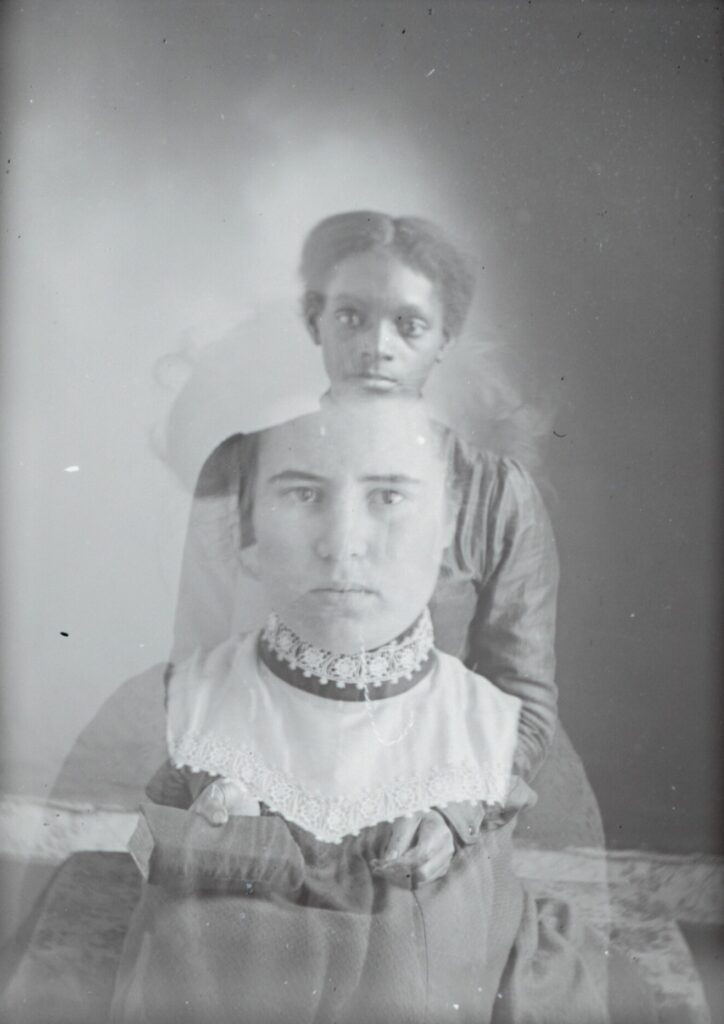 Double exposed black and white portraits of a young Black girl and a young white woman superimposed on one or another
